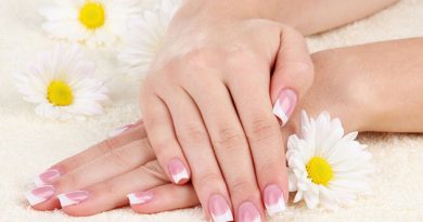 Woman hands with french manicure and flowers on towel